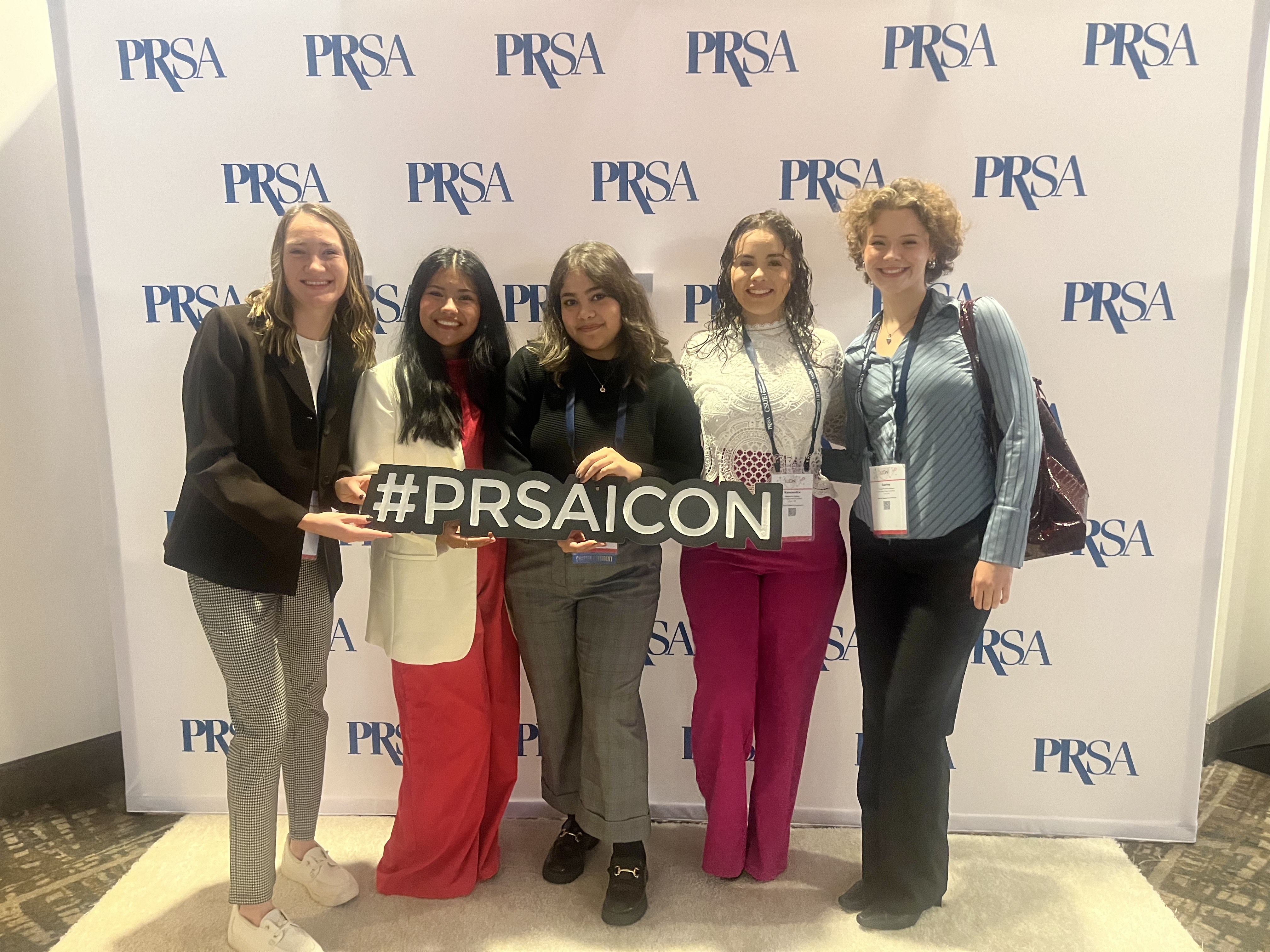 PRSSA Students Posing in Front of PRSSA Backdrop