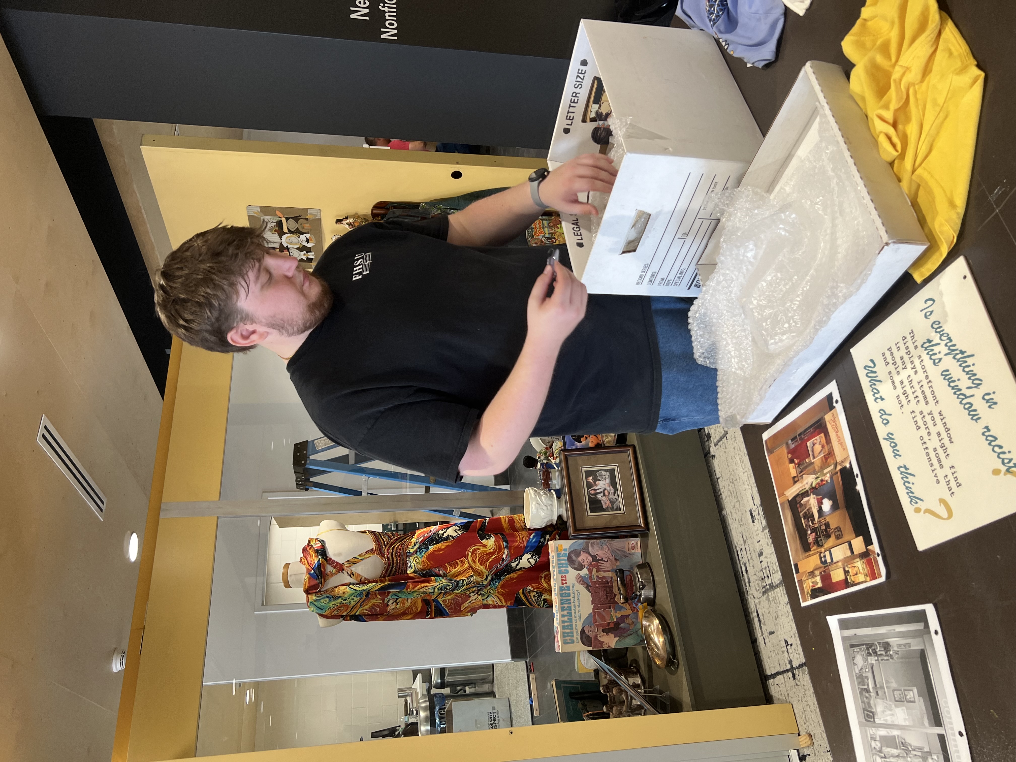 Trevor Yocum, an FHSU history graduate student from St. Mary’s, assists with setting up the “Sorting Out Race” exhibit at the Hays Public Library.